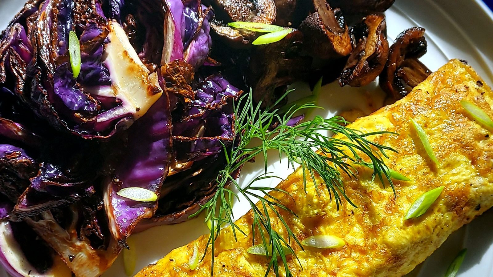 Roasted cabbage and an herbed omelet on a plate
