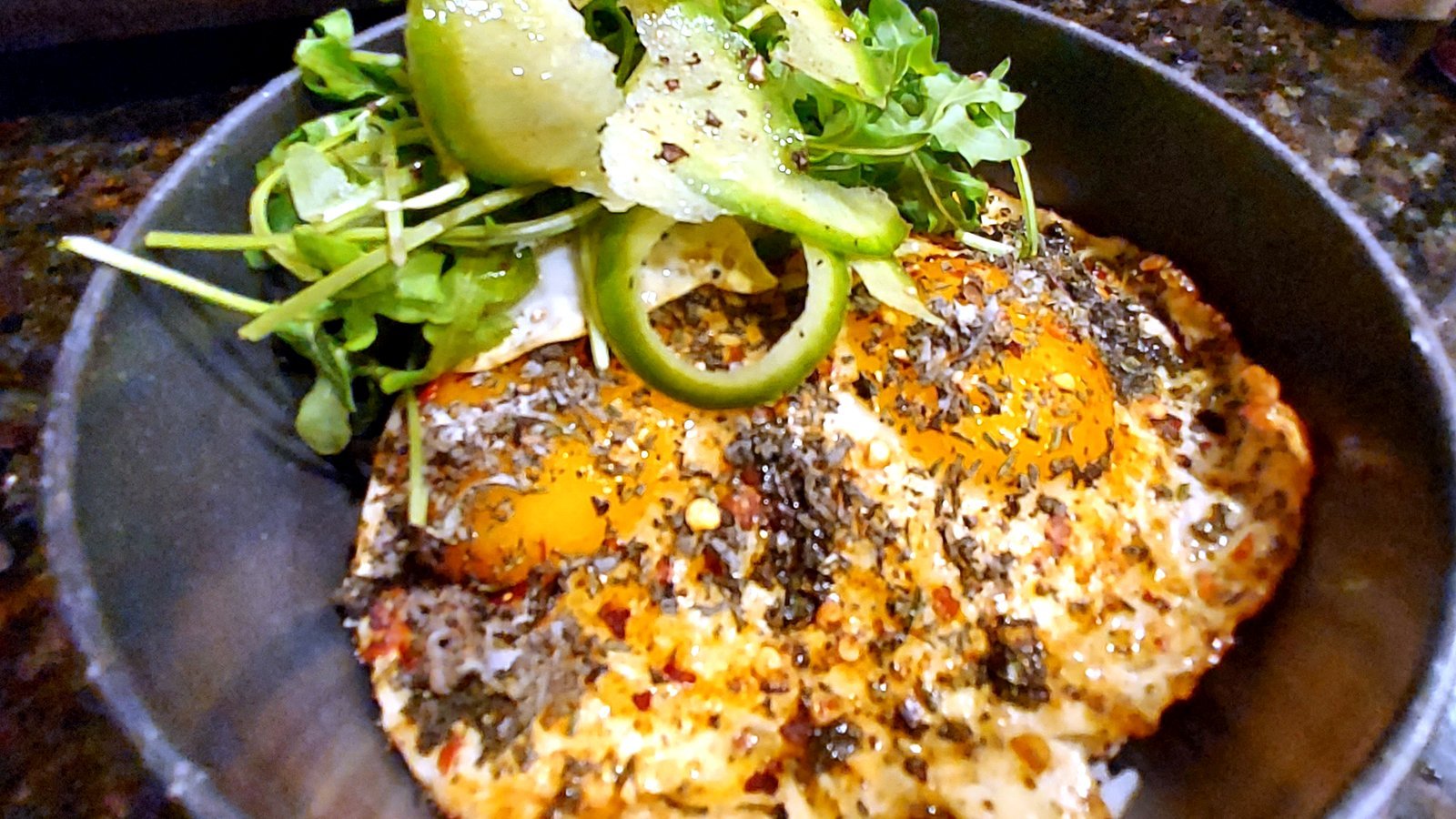 Herbed fried eggs over rice with lime and greens